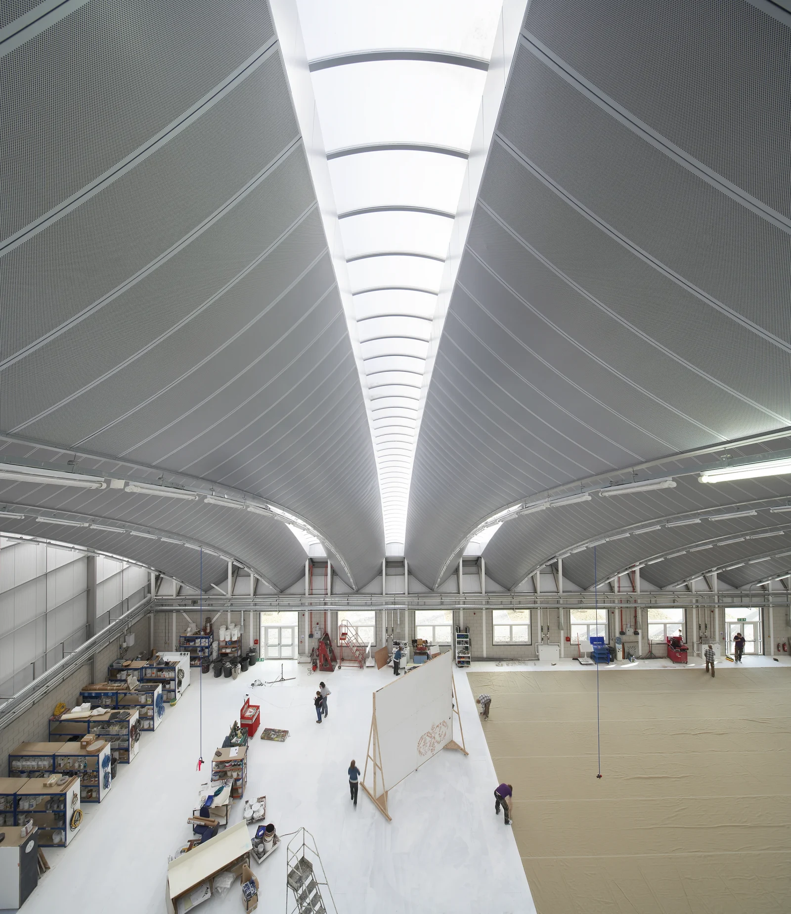 Vaulted ceiling with linear grid, service integration and large-format curved tiles